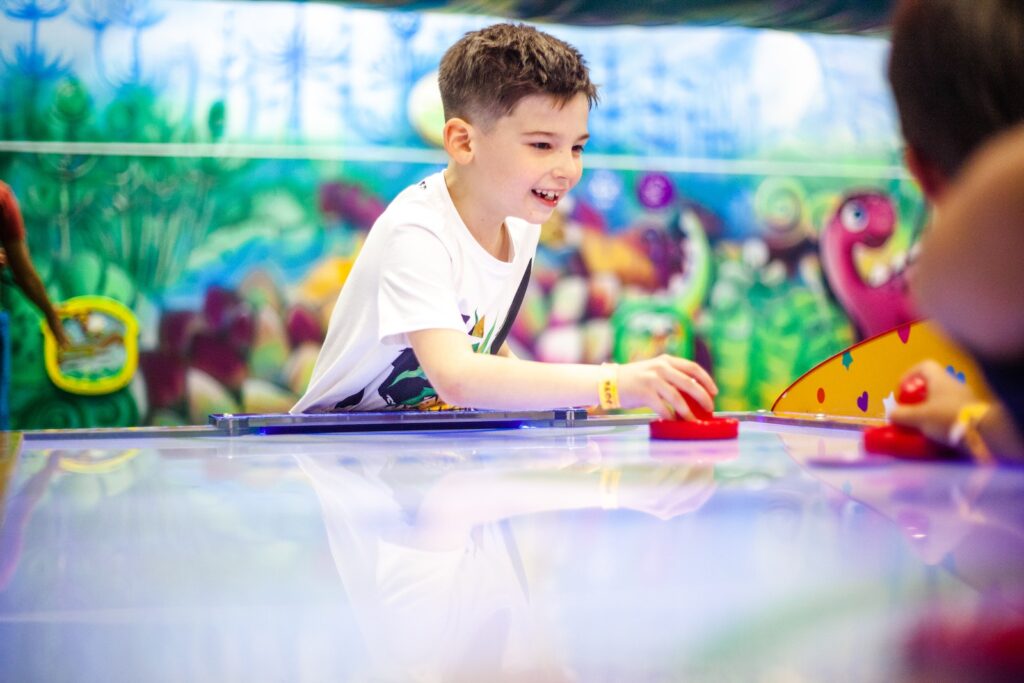 Photo of a Boy in a White Shirt Playing Table Hockey